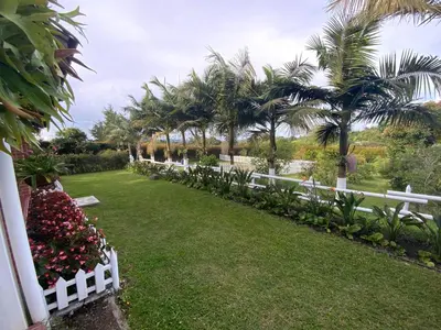 a white fence in a yard with palm trees at Finca Hotel 12 Palmas- Aeropuerto JMC in Rionegro