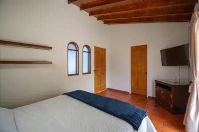 a bedroom with a bed and a flat screen tv at Finca Hotel 12 Palmas- Aeropuerto JMC in Rionegro