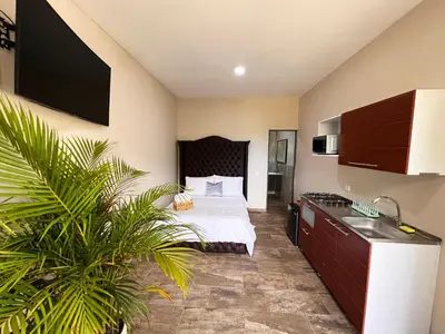 a hotel room with a bed and a kitchen at 1714 Hotel Boutique Guatapé in Guatapé