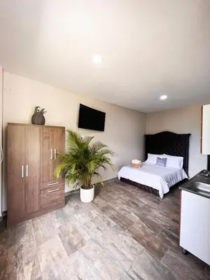 a bedroom with a bed and a tv on the wall at 1714 Hotel Boutique Guatapé in Guatapé