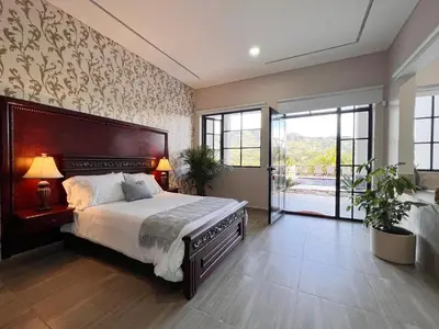 a bedroom with a large bed and a large window at 1714 Hotel Boutique Guatapé in Guatapé