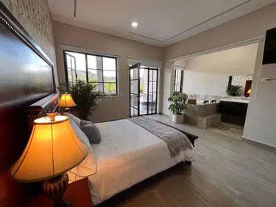 a bedroom with a large bed and a bathroom at 1714 Hotel Boutique Guatapé in Guatapé
