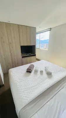 a large white bed with two slippers on top of it at 1213 Suite Moderna - Confort zona rosa poblado in Medellín
