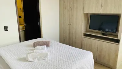 a room with a bed with towels on it with a television at 1213 Suite Moderna - Confort zona rosa poblado in Medellín