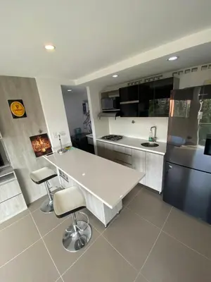 a kitchen with a white table and two stools at 1213 Suite Moderna - Confort zona rosa poblado in Medellín