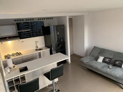 a living room with a couch and a kitchen at 1213 Suite Moderna - Confort zona rosa poblado in Medellín