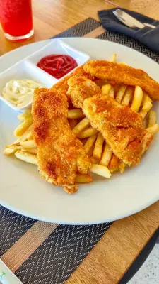 a plate of food with fried chicken and french fries at Hotel Santiago de Arma in Rionegro