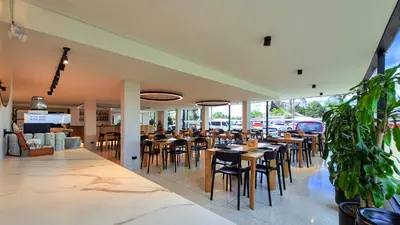 a restaurant with wooden tables and chairs and windows at Hotel Santiago de Arma in Rionegro
