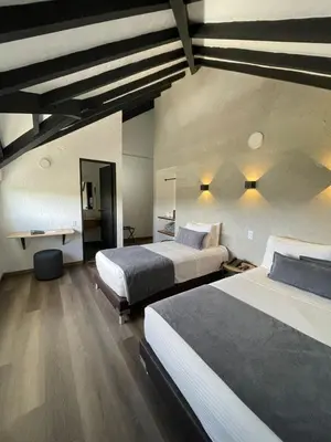 a hotel room with two beds and a desk at Hotel Santiago de Arma in Rionegro