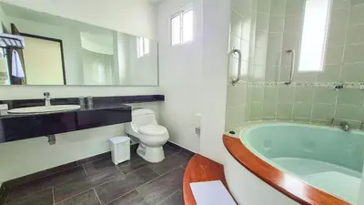 a bathroom with a tub and a toilet and a sink at Hotel Santiago de Arma in Rionegro