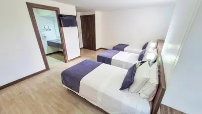 a hotel room with two beds and a mirror at Hotel Santiago de Arma in Rionegro