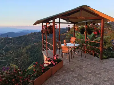 a gazebo with a table and chairs on a mountain at Mirador Finca Morrogacho in Manizales