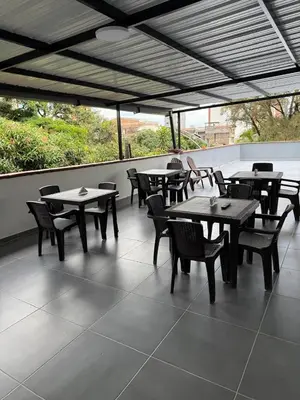 a group of tables and chairs on a patio at Hotel De León Estadio in Medellín