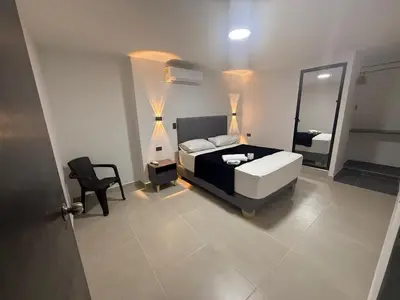 a bedroom with a bed and a mirror and a chair at Hotel De León Estadio in Medellín