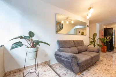 a living room with a couch and a mirror at Hotel De León Estadio in Medellín