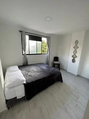 a bedroom with a large bed and a window at Medellin, elegante y central apartamento in Medellín