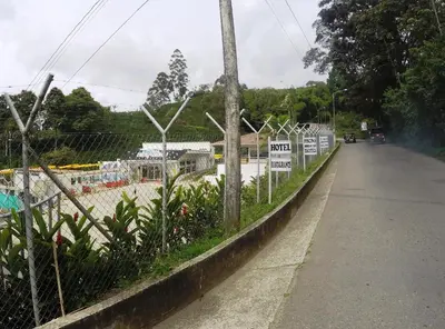 a fence with signs on it next to a road at Sky Club Eco Hotel in Belén de Umbría