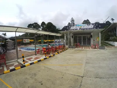 a swimming pool with a large building with a pool at Sky Club Eco Hotel in Belén de Umbría