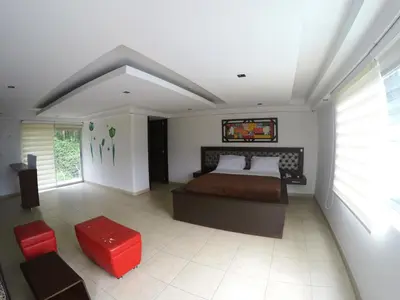 a bedroom with a bed and a red stool at Sky Club Eco Hotel in Belén de Umbría
