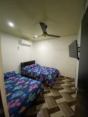 a bedroom with two beds and a ceiling fan at Apartamento bustos in Puerto Triunfo