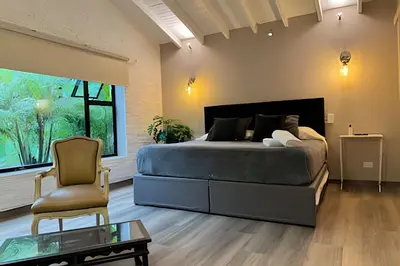 a bedroom with a large bed and a chair at Dos habitaciones, amplio, estrategicamente ubicado in El Poblado