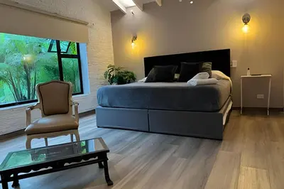 a bedroom with a bed and a chair and a table at Dos habitaciones, amplio, estrategicamente ubicado in El Poblado