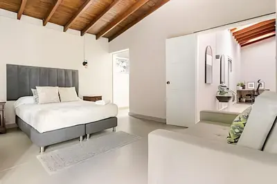 a white bedroom with a bed and a couch at NUEVA Mansion con piscina y jacuzzi, El Poblado in El Poblado