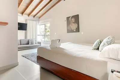 a white bedroom with a large bed and a couch at NUEVA Mansion con piscina y jacuzzi, El Poblado in El Poblado