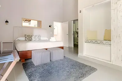 a white bedroom with a bed and a rug at NUEVA Mansion con piscina y jacuzzi, El Poblado in El Poblado