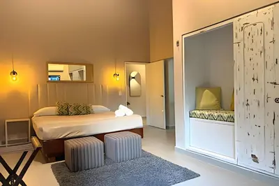 a bedroom with a bed and a mirror at NUEVA Mansion con piscina y jacuzzi, El Poblado in El Poblado