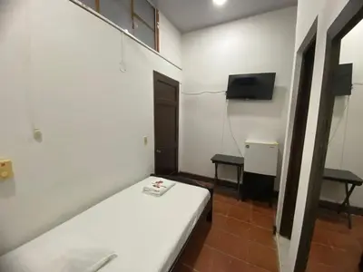 a small room with a bed and a tv at Hotel Malecon Puerto Berrio in Puerto Berrío