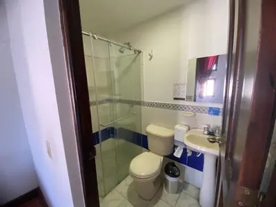 a bathroom with a shower and a toilet and a sink at Hotel Malecon Puerto Berrio in Puerto Berrío