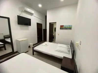 a bedroom with a bed and a tv and a mirror at Hotel Malecon Puerto Berrio in Puerto Berrío