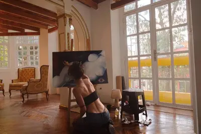 a woman sitting on the floor in a living room at Estudio Duplex Vintage en el Centro para 4H Atelier in Medellín