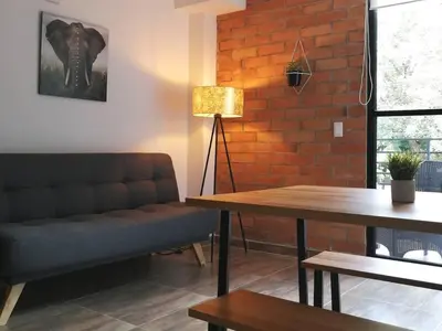 a living room with a couch and a brick wall at Apartamento en Medellín cerca al poblado in Medellín