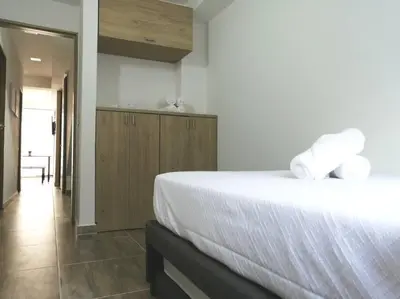 a bedroom with a large bed with white sheets at Apartamento en Medellín cerca al poblado in Medellín