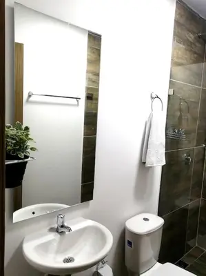 a bathroom with a sink and a toilet and a mirror at Apartamento en Medellín cerca al poblado in Medellín