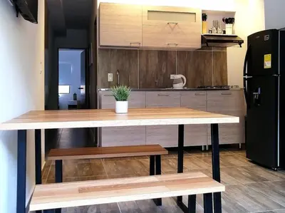 a kitchen with a table and a black refrigerator at Apartamento en Medellín cerca al poblado in Medellín