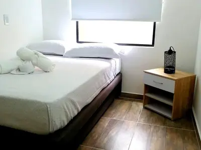 a bedroom with a bed and a nightstand with a white bed at Apartamento en Medellín cerca al poblado in Medellín
