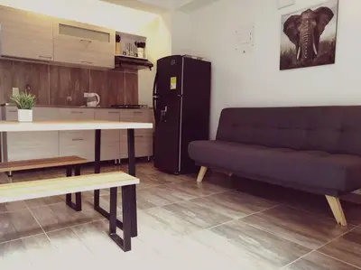 a living room with a couch and a table and a refrigerator at Apartamento en Medellín cerca al poblado in Medellín