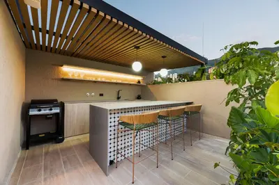 an outdoor kitchen with a bar and stools at Nakúa Stay & Work Hotel in Medellín