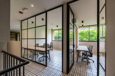 a dining room with glass walls and a table and chairs at Nakúa Stay & Work Hotel in Medellín