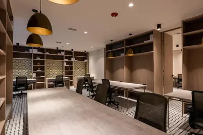 a conference room with tables and chairs and shelves at Nakúa Stay & Work Hotel in Medellín
