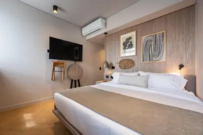 a bedroom with a large white bed and a flat screen tv at Nakúa Stay & Work Hotel in Medellín
