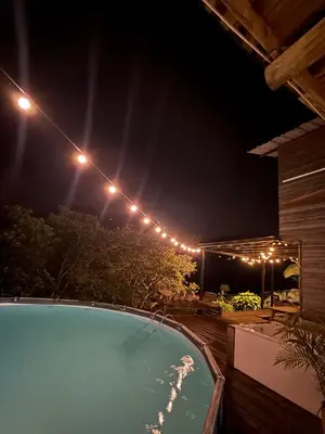 a swimming pool at night with lights above it at La Peña Cabins - Ebéjico in Ebéjico