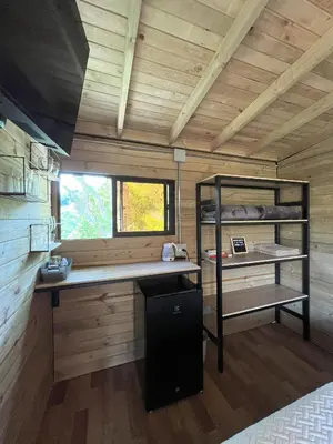 a room with a desk and a bunk bed in a cabin at La Peña Cabins - Ebéjico in Ebéjico