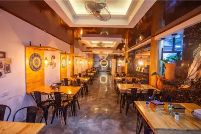 an empty restaurant with wooden tables and chairs at Hotel Buddha Mystic By Del Toro in Doradal