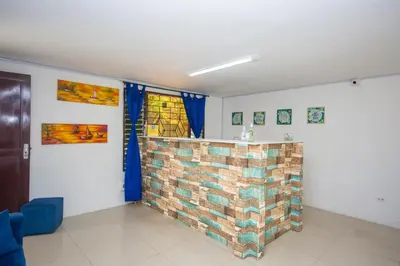 a living room with a brick wall and blue chairs at Blue Coast Hostal in Medellín