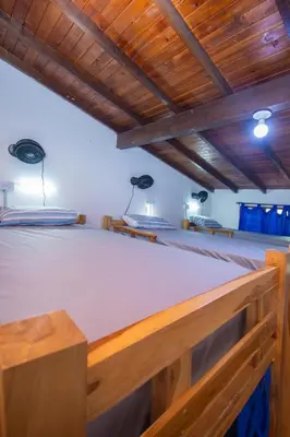 a large bed in a room with wooden ceilings at Blue Coast Hostal in Medellín