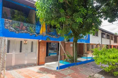 a building with a tree in front of it at Blue Coast Hostal in Medellín